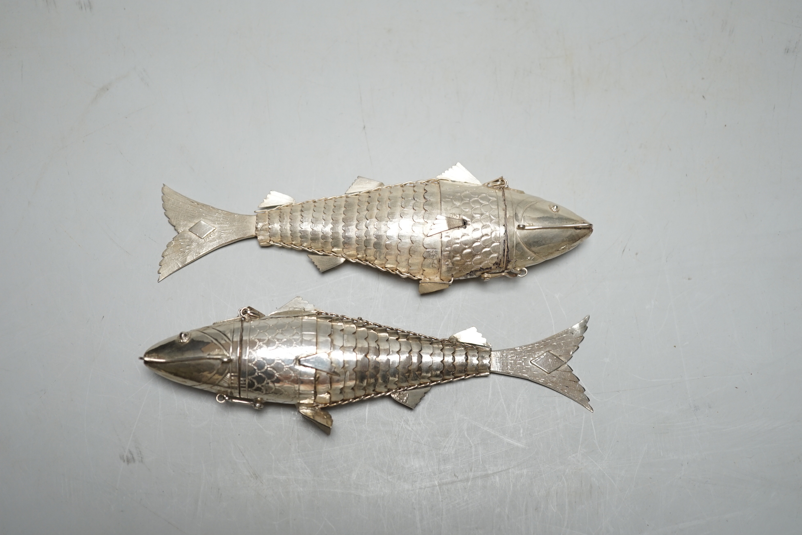 Two continental white metal pill boxes?, both modelled as a articulated fish, both approx. 13.5cm.